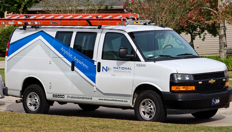 A National OnDemand installation van sits outside a customer's home. A part of  National OnDemand's Last Mile division