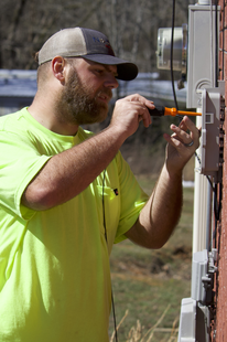 A fiber installation technician hooks up a home with fiber cable. Conquer Digital Divide