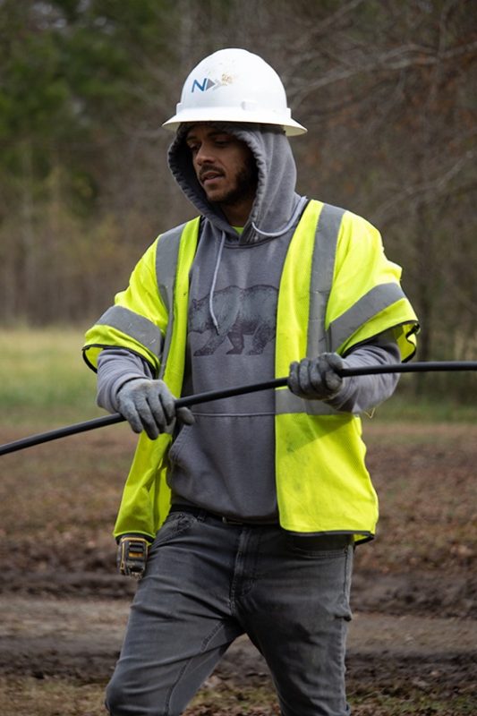 Making sure you are dressed appropriately as the weather gets cooler in the fall is part of staying safe and warm when working outdoors as seen by this cable technician.