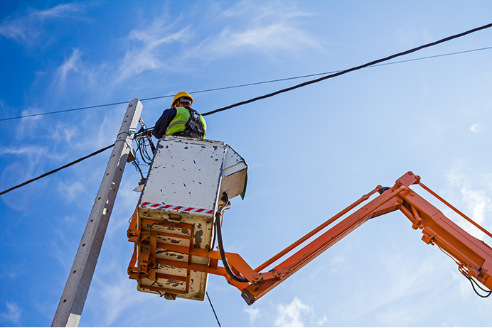 Aerial lineman work at great heights, often in challenging weather conditions.